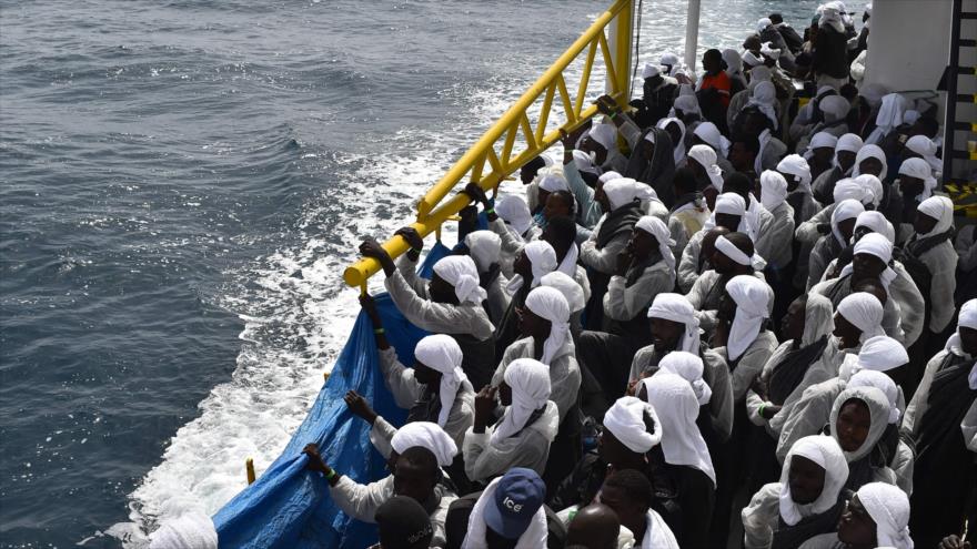 Los migrantes esperan a bordo del barco de rescate "Aquarius" tras llegar al puerto de Cagliari, Cerdeña, dos días después de haber sido rescatados cerca de las costas de Libia, 26 de mayo de 2016.