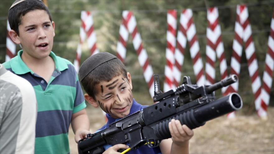 Niño israelí apunta con un arma.