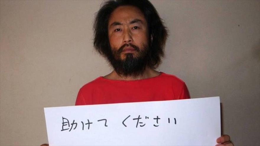 Jumpei Yasuda, periodista japonés secuestrado por los terroristas en Siria, sostiene un cartel en el que pide auxilio.