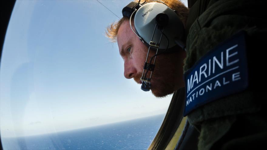 Un soldado francés a bordo de una aeronave mira por el cristal durante las operaciones de búsqueda de piezas del estrellado vuelo MS804 de EgyptAir en el mar Mediterráneo, 22 de mayo de 2016.
