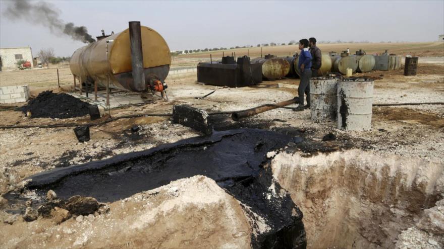 Hombres trabajan en una refinería en la provincia noroccidental de Idlib en Siria, controlada por el grupo terrorista EIIL (Daesh, en árabe).