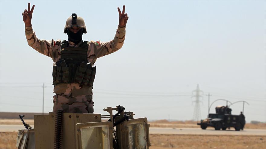 Un soldado del Ejército iraquí posa haciendo el gesto de la victoria en las afueras del barrio de Al-Shuhada, al sur de Faluya, durante las operación para liberar la ciudad de manos de Daesh, 3 de junio de 2016.