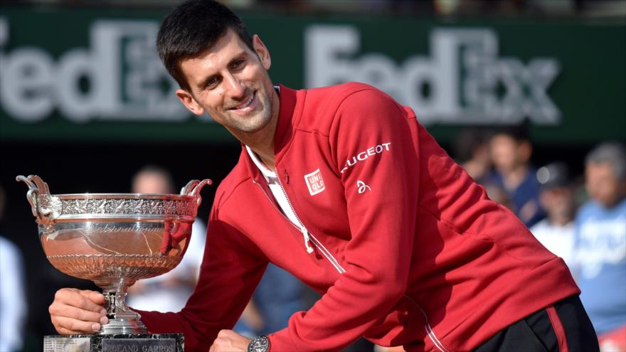 El tenista serbio Novak Djokovic posa con la copa de Roland Garros en París (capital francesa), 05 de junio de 2016.