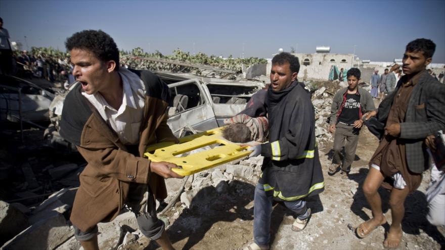 Dos hombres portan el cuerpo de un niño hallado bajo los escombros de las viviendas destruidas por los ataques aéreos saudíes en Saná, capital yemení.