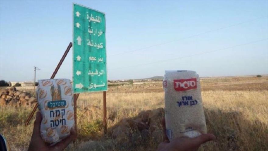 Ciudadanos sirios muestran la asistencia alimentaria israelí. 
