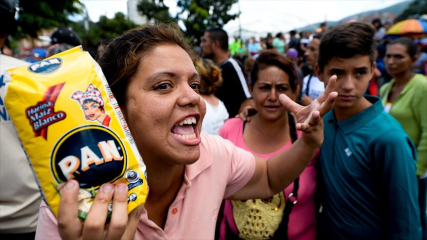 Varias personas denuncian la escasez de alimentos frente a un supermercado en el barrio de Catia, en la capital de Venezuela, 11 de junio de 2016.