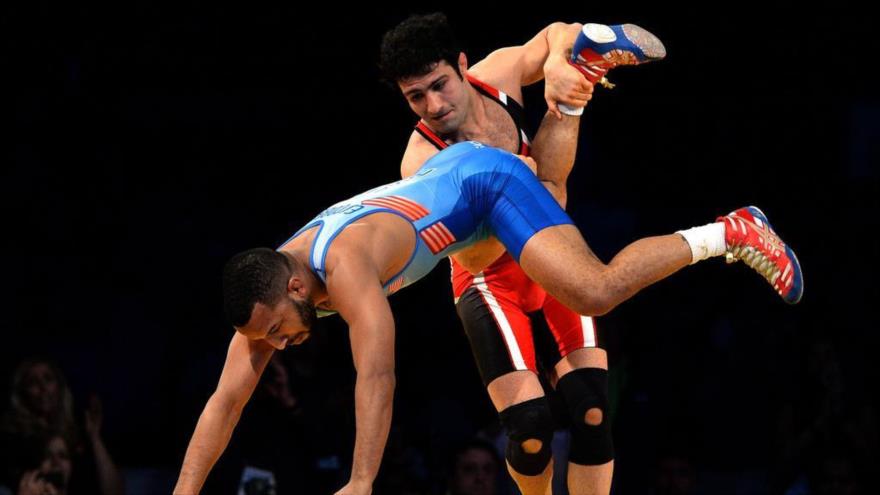 El luchar iraní Hasan Rahimi hace una llave a su rival estadounidense Daniel Dennis en la Copa Mundial de Lucha Libre, 12 de junio de 2016.