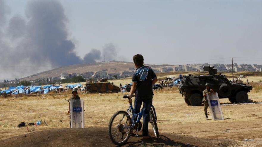 Niño kurdo-turco mira, desde la aldea Mürşitpınar Bucağı, en Suruç, en la provincia turca de Şanlıurfa, las columnas de humo provocadas por las operaciones terroristas en la ciudad siria de Kobani.