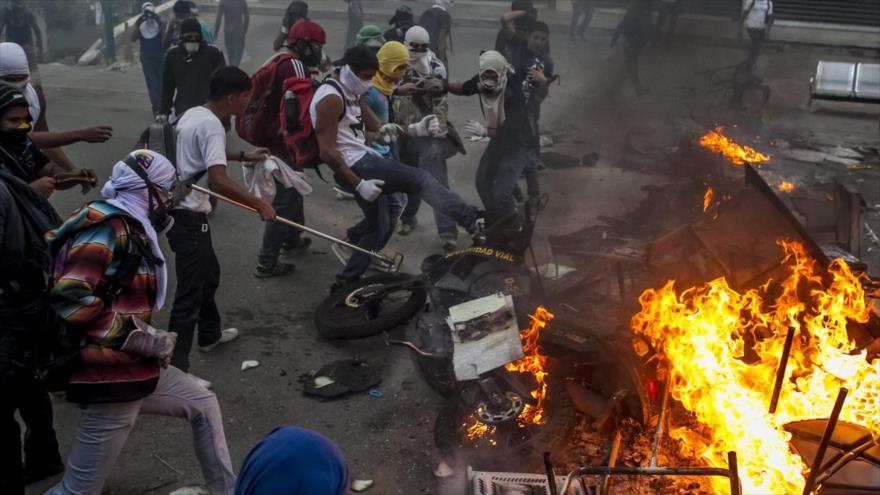 Manifestantes opositores encienden una barricada durante una protesta contra el gobierno del presidente venezolano, Nicolás Maduro.