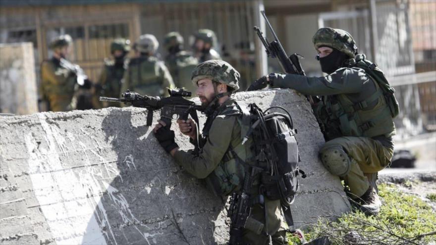 Soldados israelíes apuntan sus armas contra los palestinos en Ramalá.