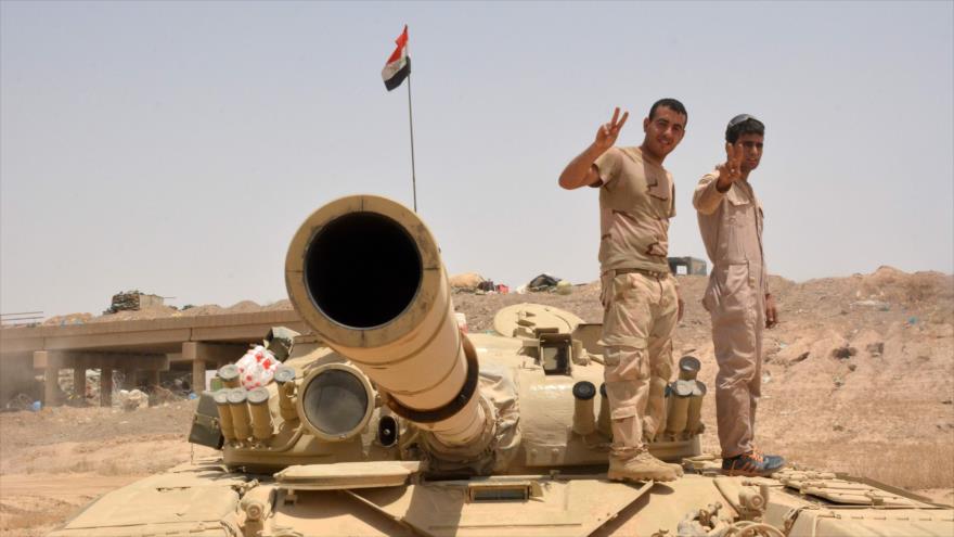 Fuerzas iraquíes hacen el signo de la victoria sobre un tanque localizado a unos 40 kilómetros al oeste de Al-Qayyarah, durante un operativo para retomar esta zona estratégica y convertirla en una base para recuperar el control de Mosul, 22 de junio de 2016.