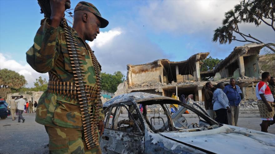 Un soldado somalí inspecciona un coche detonado por el grupo terrorista Al-Shebab en Mogadiscio, capital de Somalia, 27 de febrero de 2016.