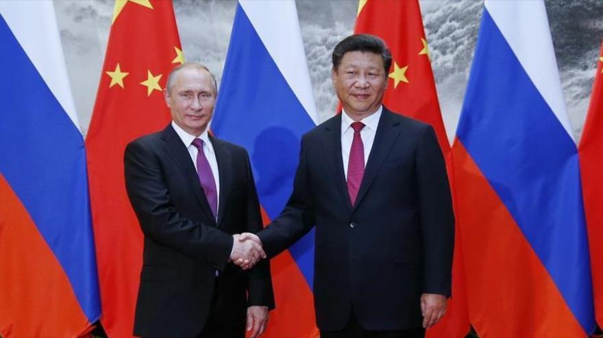 El presidente chino, Xi Jinping (dcha) y su homólogo ruso, Vladimir Putin, en Pekín, capital china, 25 de junio de 2016.