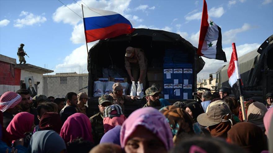 Integrantes del Centro ruso para la Reconciliación distribuyen ayuda humanitaria entre los ciudadanos sirios en la ciudad de Latakia (noroeste).