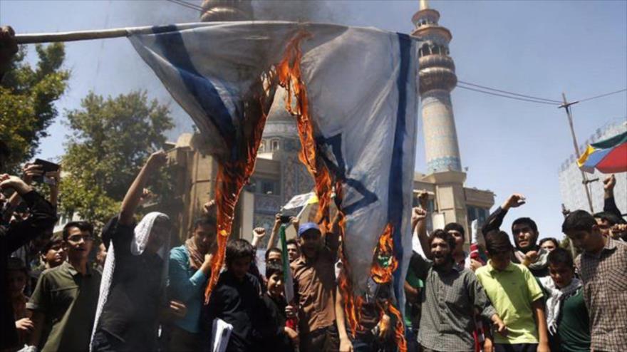Participantes en las marchas del Día Mundial de Al-Quds en Teherán, capital iraní, prenden fuego a una bandera israelí.