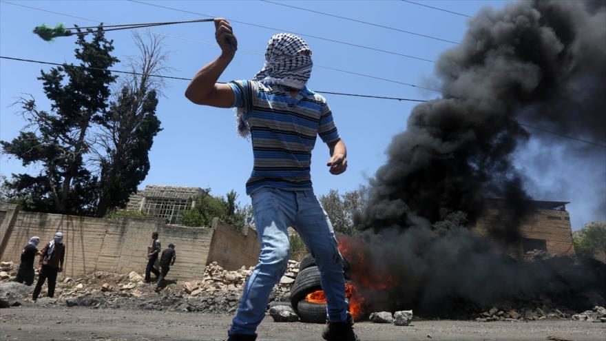 Un palestino lanzando piedras contra soldados israelíes en la aldea Kfar Qaddum, cerca de la ciudad cisjordana de Nablus.