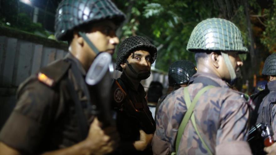 Personal de seguridad de Bangladés hacen guardia cerca del restaurante atacado en Daca.