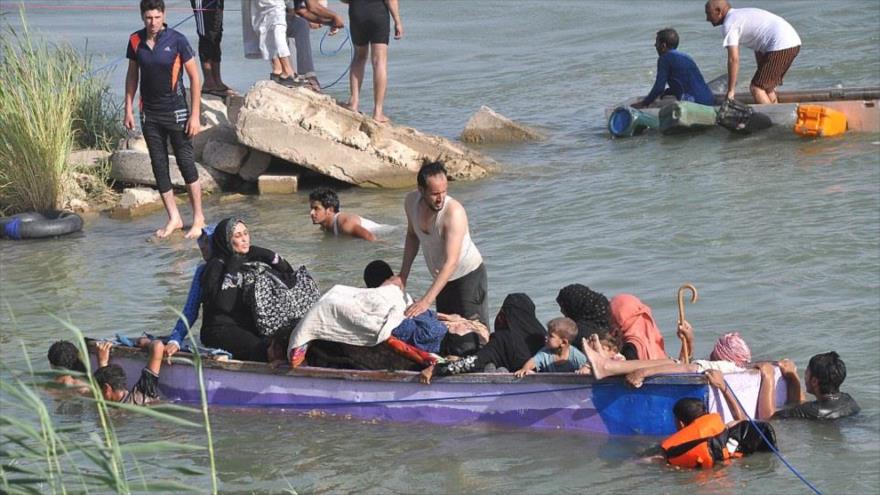 Ciudadanos iraquíes cruzan el río Éufrates para huir de la ciudad de Faluya, ocupada por el grupo terrorista EIIL (Daesh, en árabe).