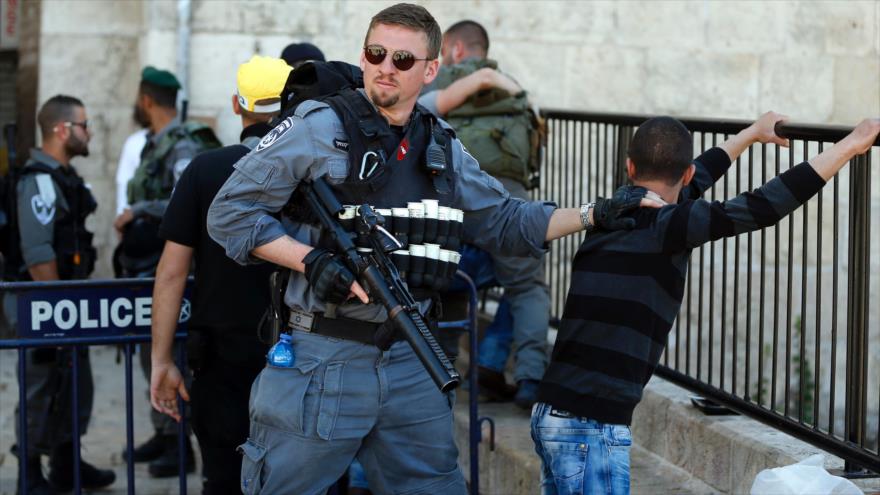 Un agente de la policía israelí cachea un joven palestino después del rezo del viernes en Al-Quds (Jerusalén), 19 de febrero de 2016.