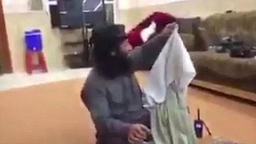 Una imagen captada de un vídeo que demuestra cómo un integrante del grupo terrorista EIIL (Daesh, en árabe) hace gestiones con la ropa interior de su amigo violador.