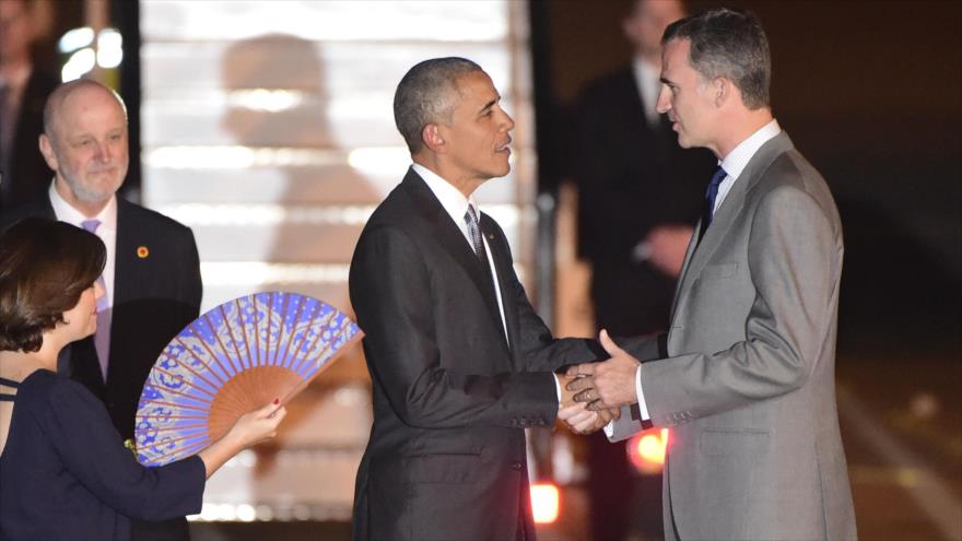 El jefe de Estado español, el rey Felipe VI (dcha.), recibe al presidente estadounidense, Barack Obama, al pie de las escalerillas de su avión en Madrid, mientras la vicepresidente del Gobierno de España, Soraya Sáenz de Santamaría (izda.), abanica, 9 de julio de 2016.