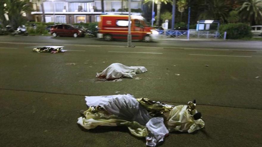 Los cuerpos sin vida de tres de las víctimas del atentado en Niza, ciudad ubicada en el sureste de Francia, yacen sobre el suelo.