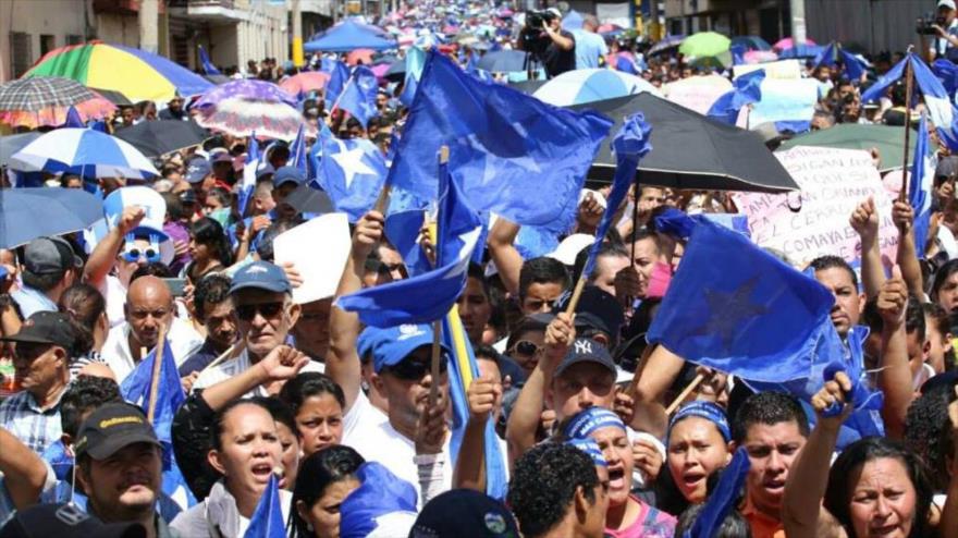 Partidarios y simpatizanes del gobernante Partido Nacional marchan en Tegucigalpa, capital hondureña, a favor de la reelección presidencial, 17 de julio de 2016.