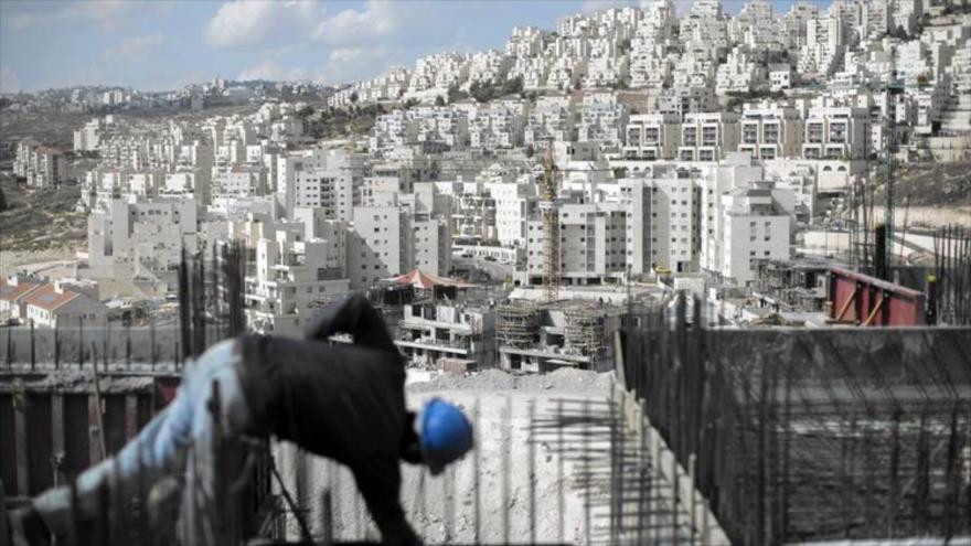 Un obrero trabaja en un sitio de construcción en el asentamiento de Har Homa, en el sur de Al-Quds, donde Israel está construyendo más unidades. 