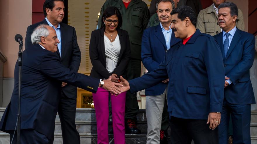 El secretario general de la Unión de Naciones Suramericanas (Unasur), Ernesto Samper (izda), le estrecha la mano al presidente venezolano Nicolás Maduro (dcha), en frente al (desde izda) expresidente panameño, Martin Torrijos, la canciller venezolana Delcy Rodriguez, el expresidente español Luis Rodríguez Zapatero y el dominocano Leonel Fernández, durante una conferencia de prensa en el palacio de Miraflores en Caracas, capital de Venezuela. 21 de julio de 2016