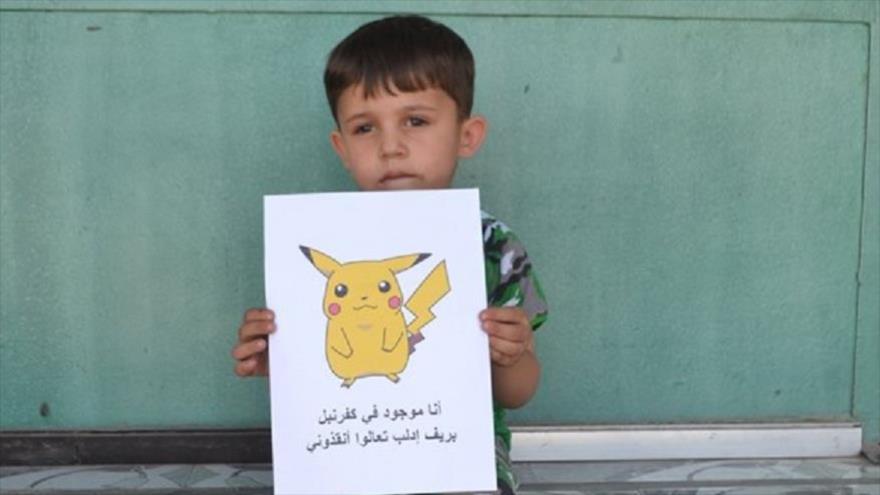 Un niño sirio sostiene su dibujo de uno de los personajes del universo de Pokémon.