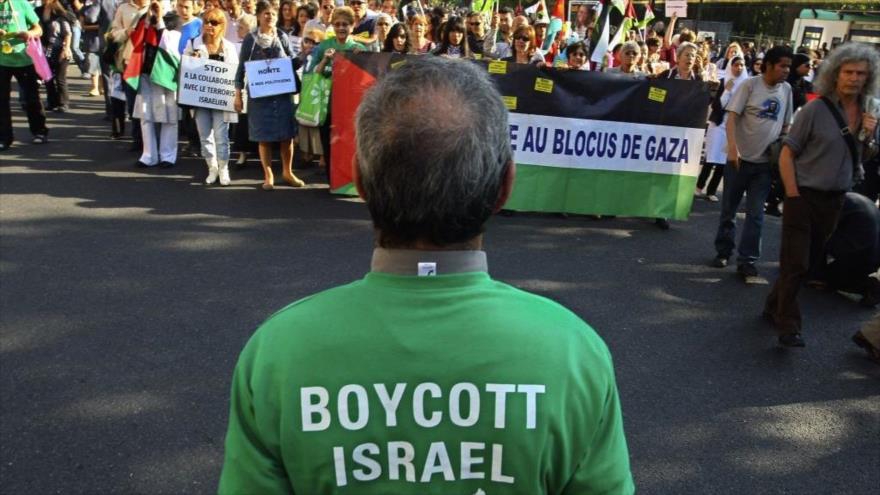 Un manifestante asiste a una manifestación propalestina en Francia con una camiseta pro boicot a Israel.