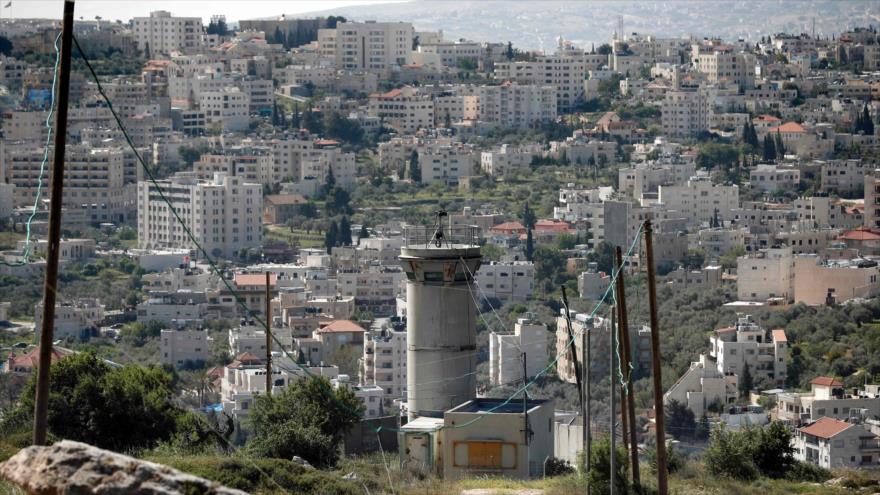 Una foto tomada desde el asentamiento ilegal israelí de Guiló, en Al-Quds (Jerusalén), muestra una torre de vigilancia del régimen israelí con vistas a la ciudad palestina de Beit Yala, 7 de abril de 2016.