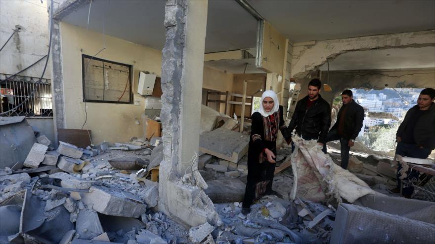 Palestinos buscan sus cosas debajo de los escombros de su vivienda destruida por el régimen de Israel en Karam al-Masri, Cisjordania, 1 de octubre de 2015.