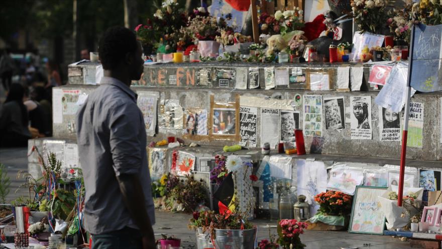 Un hombre mira los mensajes depositados al pie de un monumento de la República en París, capital francesa, después de que un sacerdote fuera asesinado por dos terroristas en una iglesia en Normandía, 26 de julio de 2016.