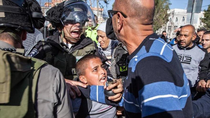  Un efectivo israelí detiene a un menor de 11 años de edad, identificado como Ahmad Abu Sbitanm, por supuestamente haber lanzado piedras contra los soldados israelíes, 19 de julio de 2015.