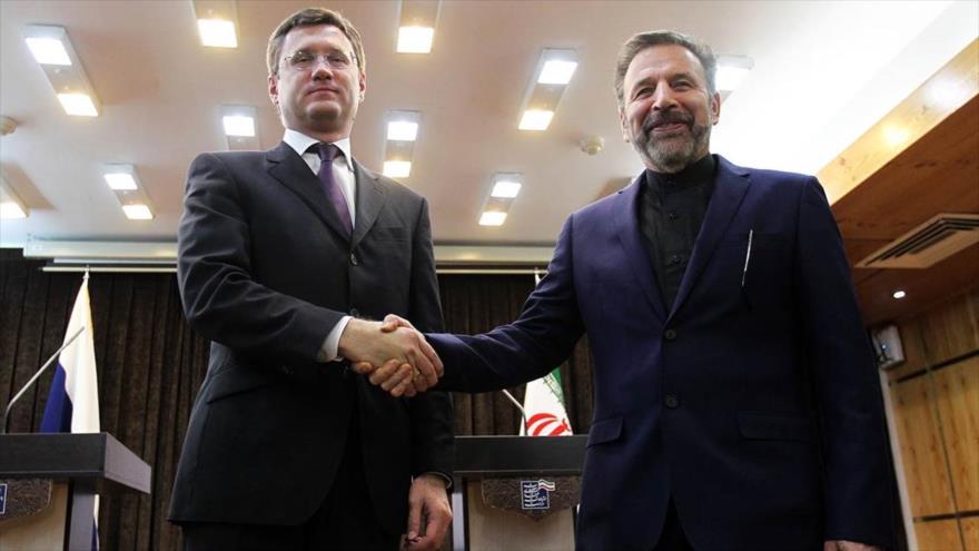 El ministro de Energía de Rusia, Alexander Novak (izqda.), y el ministro iraní de Tecnología de la Información y las Comunicaciones, Mahmud Vaezi, se estrechan la mano.