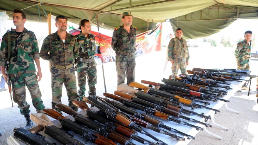 Un grupo de hombres armados entrega las armas al Ejército sirio en Damasco, capital siria.