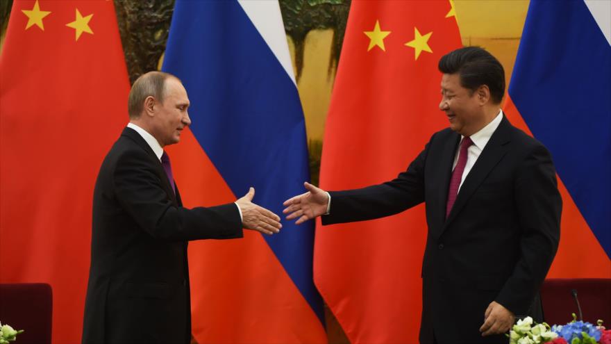 El presidente de China, Xi Jinping (izda.), saluda a su par ruso, Vladimir Putin, 25 de junio de 2016.