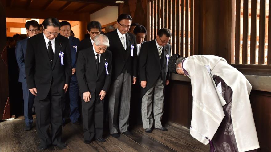 Un sacerdote Shinto (dcha.), saluda a los legisladores japoneses que visitan el polémico santuario de Yasukuni en el 71 aniversario de la rendición de Japón en la Segunda Guerra Mundial, en Tokio, 15 de agosto de 2016. 