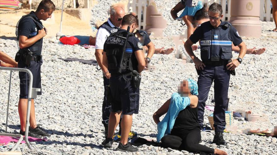 Policía de la ciudad francesa de Niza, obliga a una mujer musulmana, quitarse parte de su Burkini. 24 de agosto de 2016