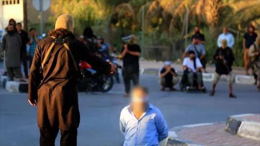 Miembro del grupo terrorista EIIL (Daesh, en árabe) se prepara para matar a un civil.