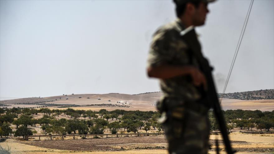 Soldado turco patrulla frontera turco-siria mientras tanques y camiones pertenecientes al Ejército turco se dirigen hacia la ciudad siria de Yarabulus.