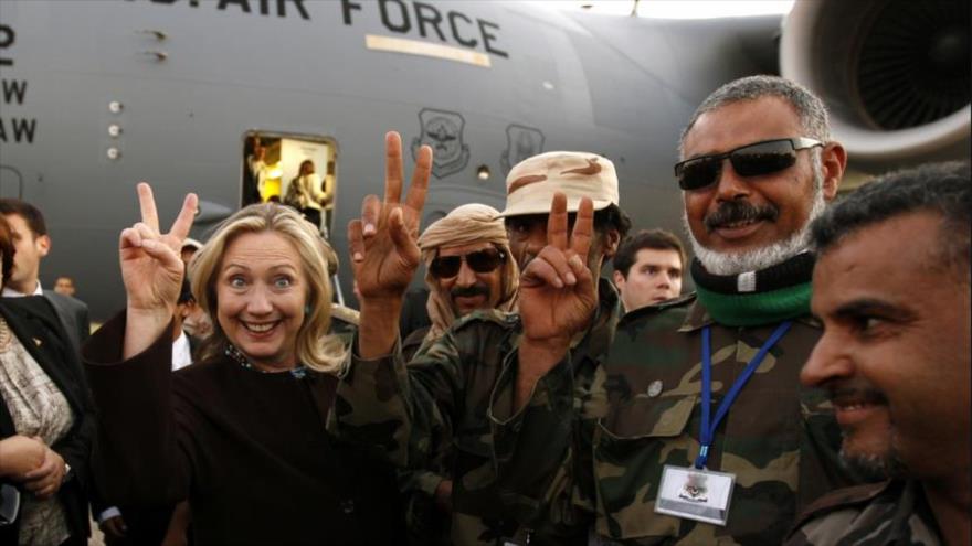 La candidata presidencial demócrata, Hillary Clinton (izda.), como secretaria de Estado estadounidense junto con combatientes apoyados por Washington para el derrocamiento del dictador Muamar Gadafi en la capital libia, Trípoli, 18 de octubre de 2011.