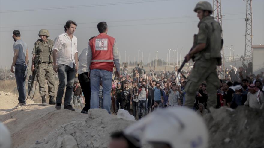 Refugiados sirios en la frontera con Turquía esperan la autorización para entrar en el suelo turco, junio de 2015.