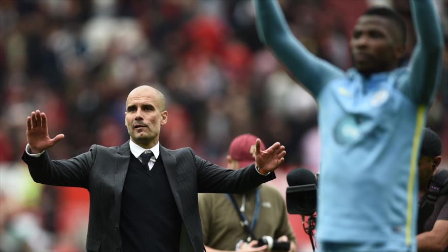 Pep Guardiola (fondo), entrenador español del club de fútbol Manchester City, celebra junto a sus jugadores en el estadio Old Trafford, en la ciudad inglesa de Manchester, la victoria de su equipo ante su rival de la misma ciudad, el Manchester United, al término de un partido en el marco de la liga inglesa, la Premier League. 10 de septiembre de 2016