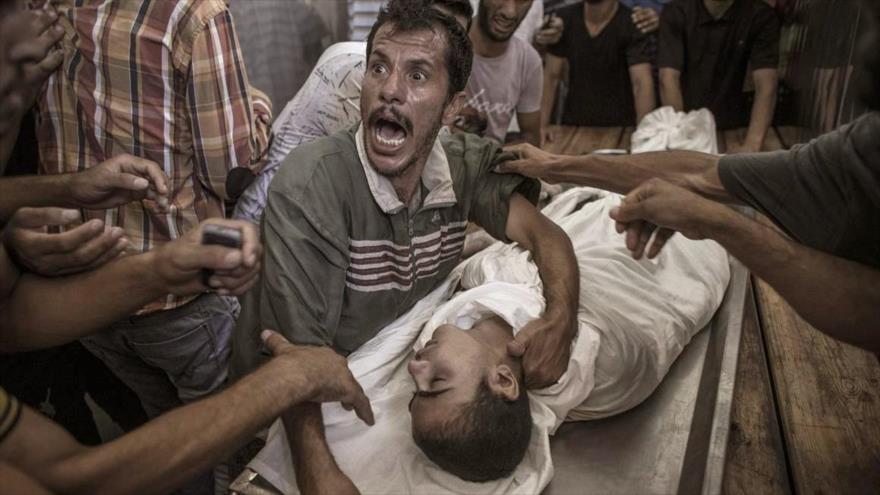Padre palestino llora por la muerte de su hijo en un bombardeo israelí contra la Franja de Gaza, 3 de agosto de 2014.