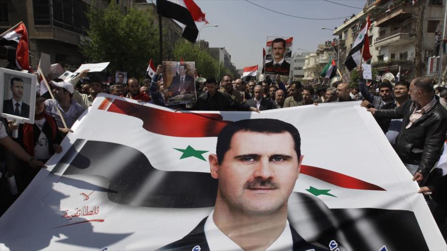 Partidarios del presidente sirio, Bashar al-Asad, portan pancartas con la imagen del líder sirio.