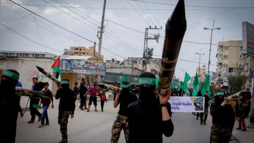 Enmascarados miembros de HAMAS portan cohetes durante una manifestación en la Franja de Gaza.