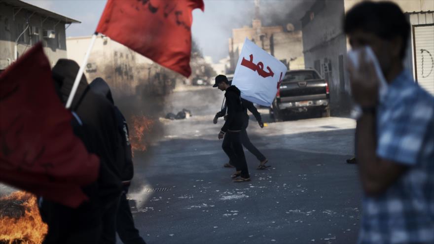Manifestantes bareiníes intentan escapar de los gases lacrimógenos lanzados por las fuerzas gubernamentales en el sur de Manama (capital), 12 de febrero de 2016.