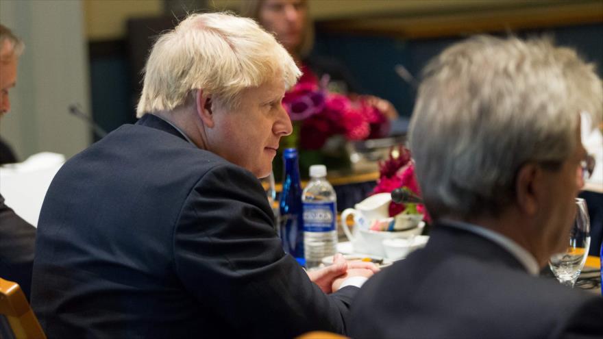 El secretario británico de Asuntos Exteriores, Boris Johnson (izda.), escucha un discurso de su homólogo estadounidense, John Kerry, en Medford (estado nororiental de Massachusetts), 24 de septiembre de 2016.